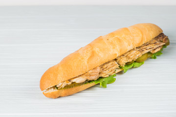 Fresh submarine sandwich with ham, cheese, tomatoes, cucumbers, lettuce and onions isolated on white background