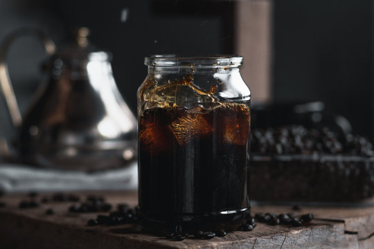 coffee In a glass bottle,Coffee drip,Hand holding a kettle Drip Coffee In the room,Black coffee in glass