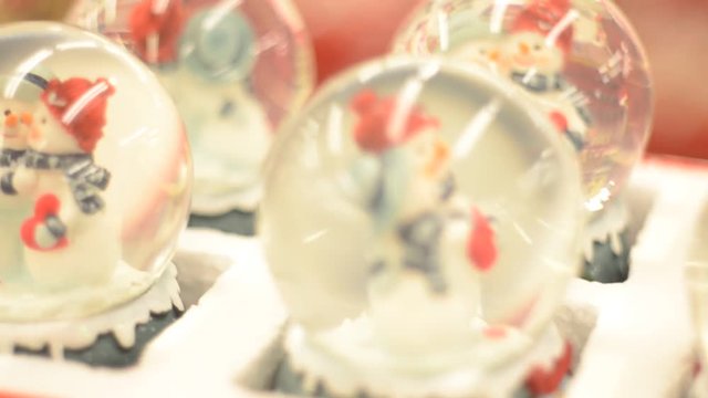 Close up of snow globe Christmas decorations on a shelf.