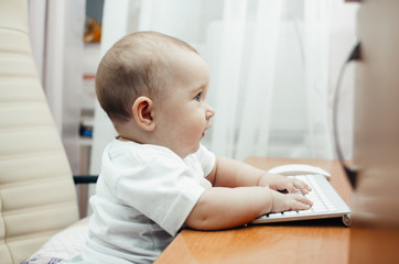 cute little baby girl typing on keyboard sitting at computer - Powered by Adobe