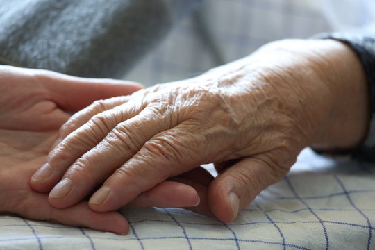 an old woman's hand and nurses