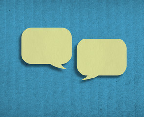 two yellow paper speech bubbles on blue cardboard background