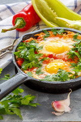 Shakshuka. Frying pan with eggs in tomato sauce.