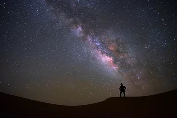 Afwasbaar fotobehang Milky way galaxy with a man standing and watching at Tar desert, Jaisalmer, India. Astro photography. © tanarch