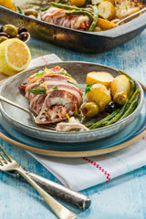 Bacon-wrapped haddock stuffed with crayfish tails, with lemony new potatoes, green beans and olives
