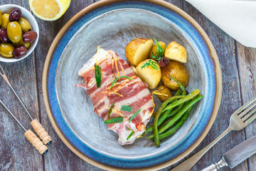 Bacon-wrapped haddock stuffed with crayfish tails, with lemony new potatoes, green beans and olives - top view