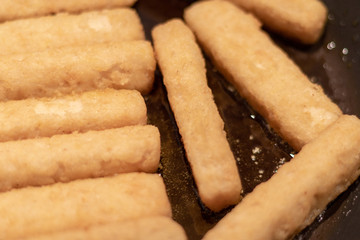 Nahaufnahme von mehreren Fischstäbchen in einer Bratpfanne