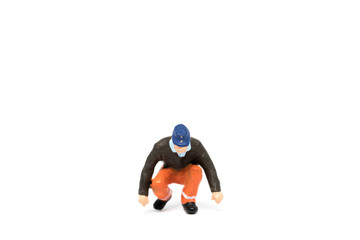 Miniature people worker wearing safety construction on white background with a space for text