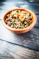 Bamboo bowl of boiled buckwheat with fried champignon, spinach and red beans