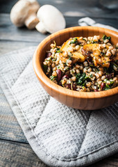 Bamboo bowl of boiled buckwheat with fried champignon, spinach and red beans