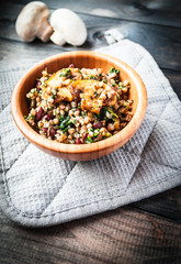 Bamboo bowl of boiled buckwheat with fried champignon, spinach and red beans