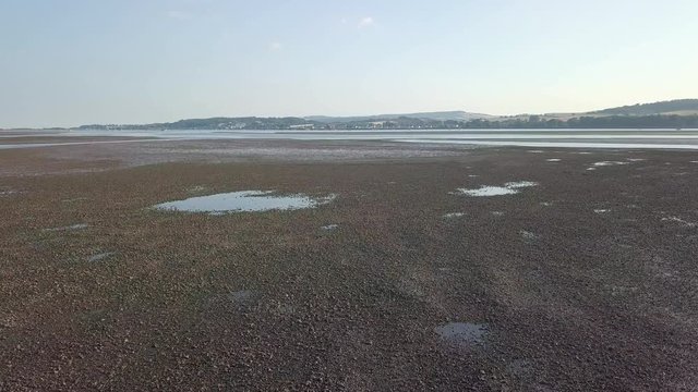Lympstone harbour, England. Beautiful 4K aerial footage at low tide, countryside background.