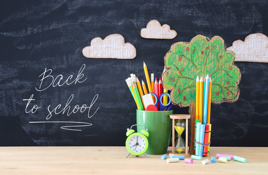 Back to school banner. tree of knowledge and pencils in front of classroom blackboard.
