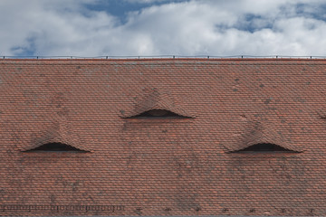 Old Roof Made of Roof Tiles with Skylights and Blue Sky