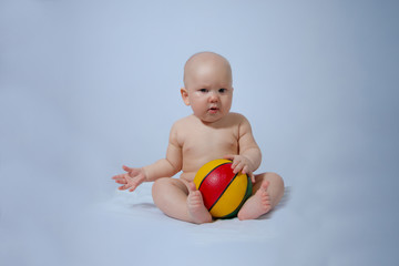 portrait of a kid who plays his ball on a gentle blue-gray background like the sky