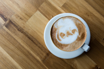 Latte art coffee cup  on wooden table, top view