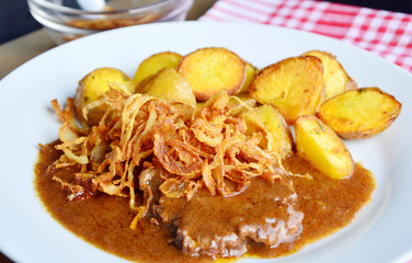 onion-topped roast beef with gravy is the favorite dish in Austria. (German name is Zwiebelrostbraten)
Beef,potatoes and onion menu in European style.