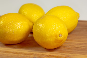 Group of lemons on a cutting board in the kitchen waiting to be sliced