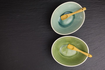 two glazed ceramic bowls on black slate plate