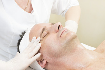 Fototapeta na wymiar Man in the mask cosmetic procedure in spa salon 