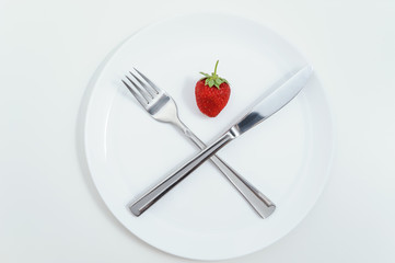 Knife, fork and ripe strawberries.