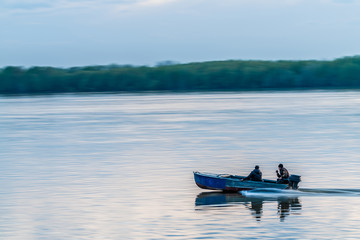 Fototapeta na wymiar Boat on river with two mens