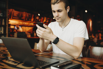 Young man in headphones using smartphone