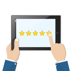 Ranking on tablet. Hands holding black tablet with yellow rank stars on screen. Man chooses stars for review and rating. Concept of voting and evaluation.