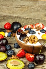 Yogurt with summer fruit on an old wooden table. Fruit refreshment. Snack for children.