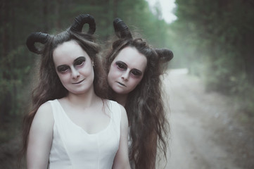 Two twins demons with horns in forest