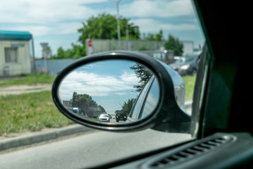 View from the car in the side rear view mirror