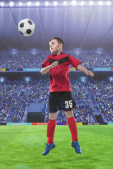 football player hitting the ball with head on a soccer stadium