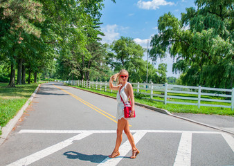 Beautiful fashionable woman walking in the crosswalk