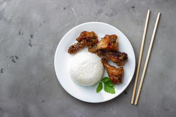 Teriyaki chicken with rice on gray background. Top view.