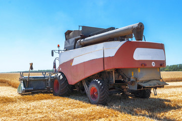 Harvester machine to harvest wheat field working. Combine harvester agriculture machine harvesting golden ripe wheat field. Agriculture