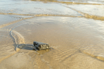 Stone in Sand with Water Ripples