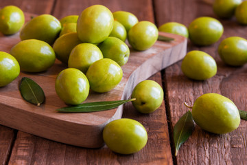 Fresh green olives on wooden table