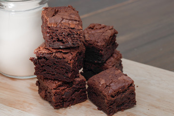 homemade cake chocolate brownies and milk on wooden table