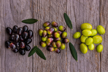 Different types of olives on wood