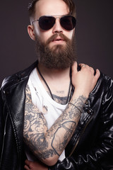 fashionable hipster man with tattoo and sunglasses