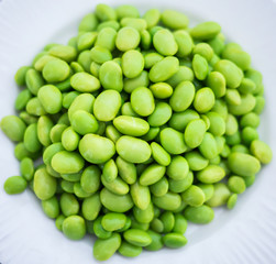 Edamame soy beans green color on dish white