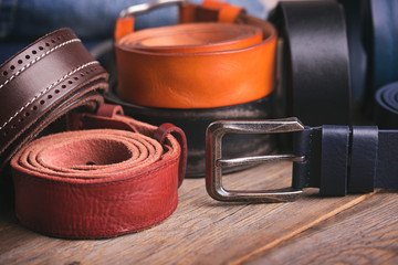 Leather colored belts on a wooden table