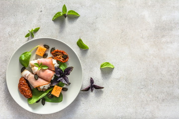 Italian food on platter, appetizer with prosciutto and cheese. Antipasti or snack for lunch.