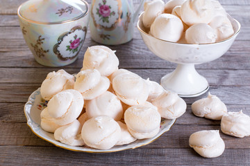 Small homemade white meringue cake on wooden table