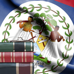 Education concept - Stack of books and reading glasses against National flag of Belize