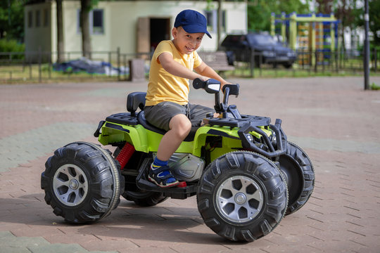 Portrait of a happy child on an ATV. The boy drives a car in an amusement park