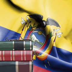 Education concept - Stack of books and reading glasses against National flag of Ecuador