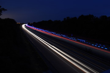 Langzeitbelichtung in der Nacht. Durch das Bild ist ein RTW gefahren.