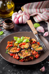 Fried eggplant slices with tomatoes, herbs and garlic, tasty vegetarian summer lunch. Grilled aubergine