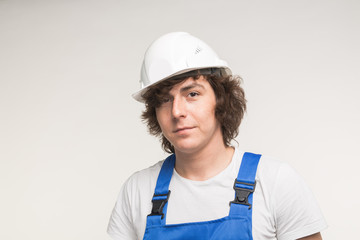 Construction, building and workers concept - Caucasian male builder wearing white helmet.